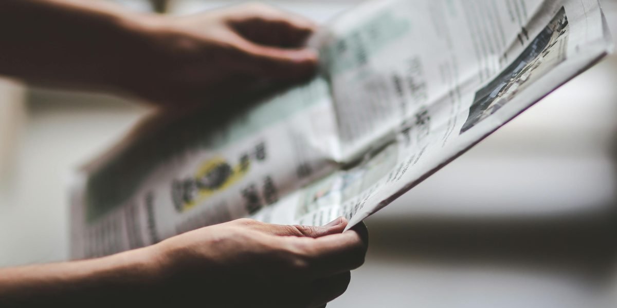 A person thoughtfully reviewing information, reflecting on the challenge of distinguishing reliable news.