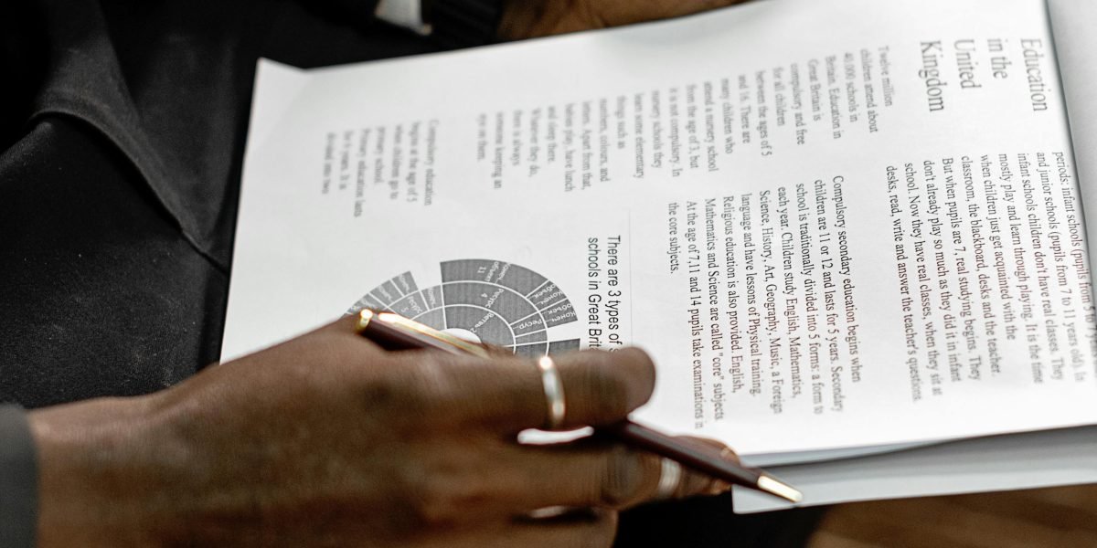 A professional meticulously reviewing data reports, embodying the critical thinking needed to identify and mitigate bias in algorithms.