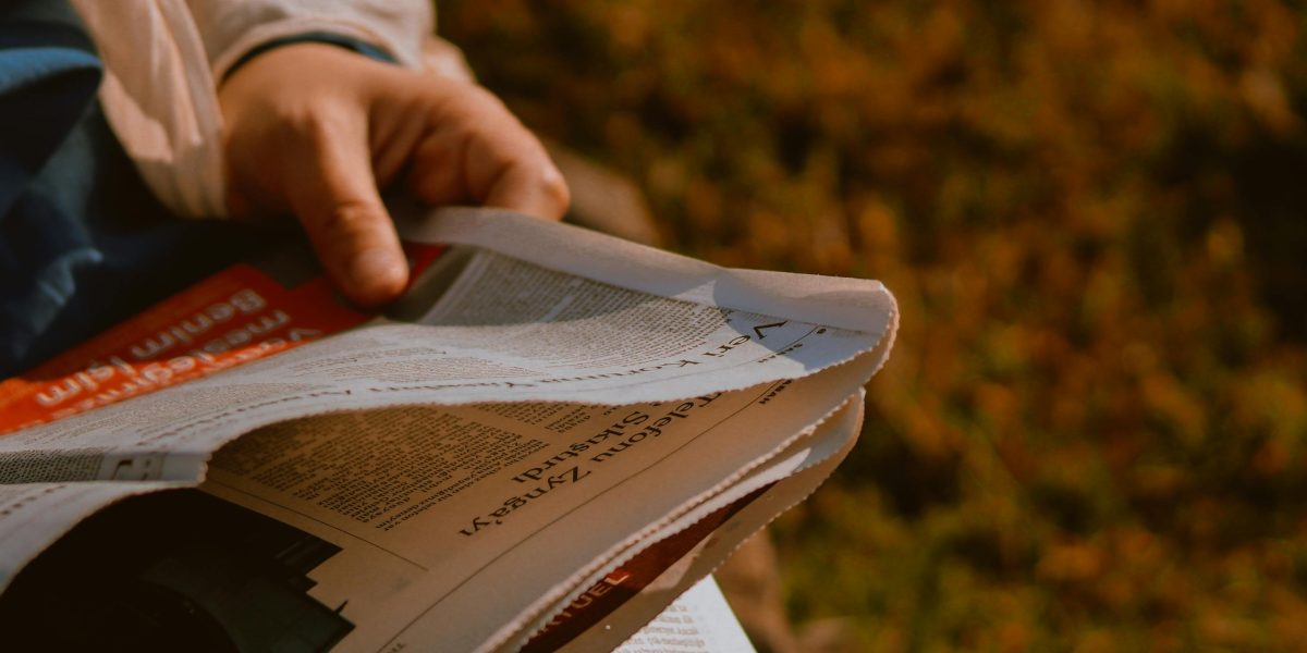 A person engrossed in reading news, actively evaluating information to discern fact from opinion.