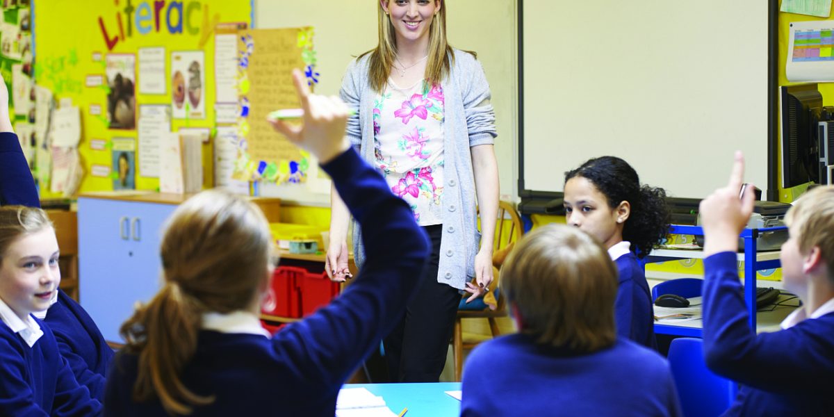 An educator actively teaching students about media literacy and critical thinking in a classroom setting.