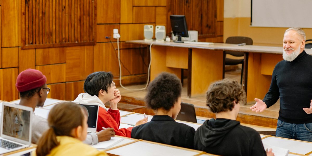 An educator engaging with students in a classroom, teaching critical thinking and media literacy skills in the age of AI.
