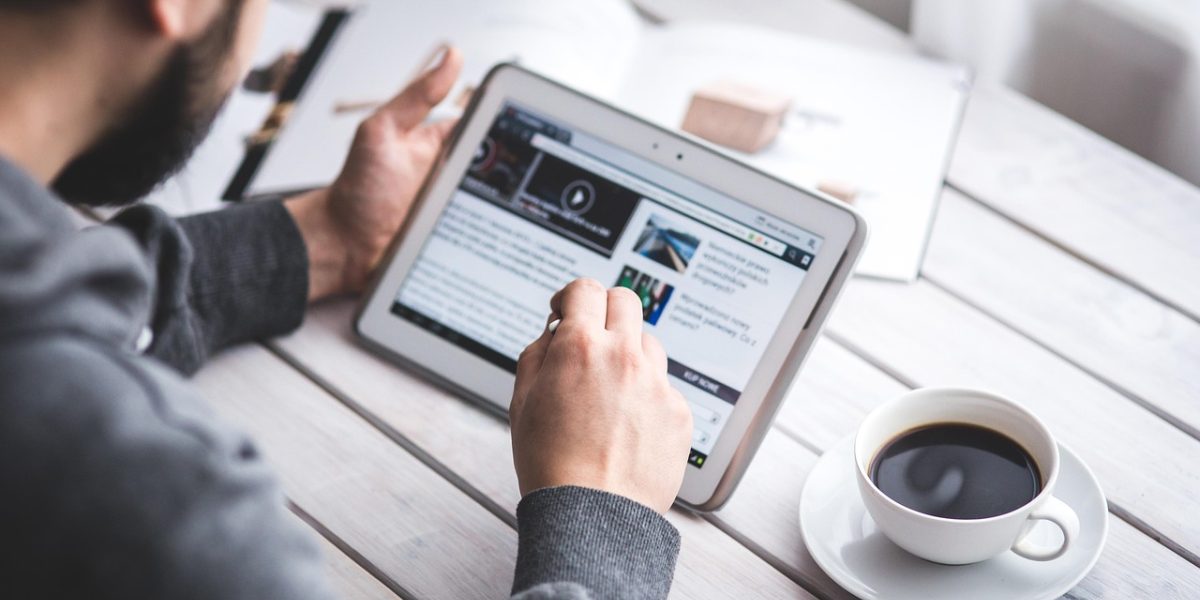 A person engages with news content on a tablet, symbolizing a thoughtful approach to information consumption.