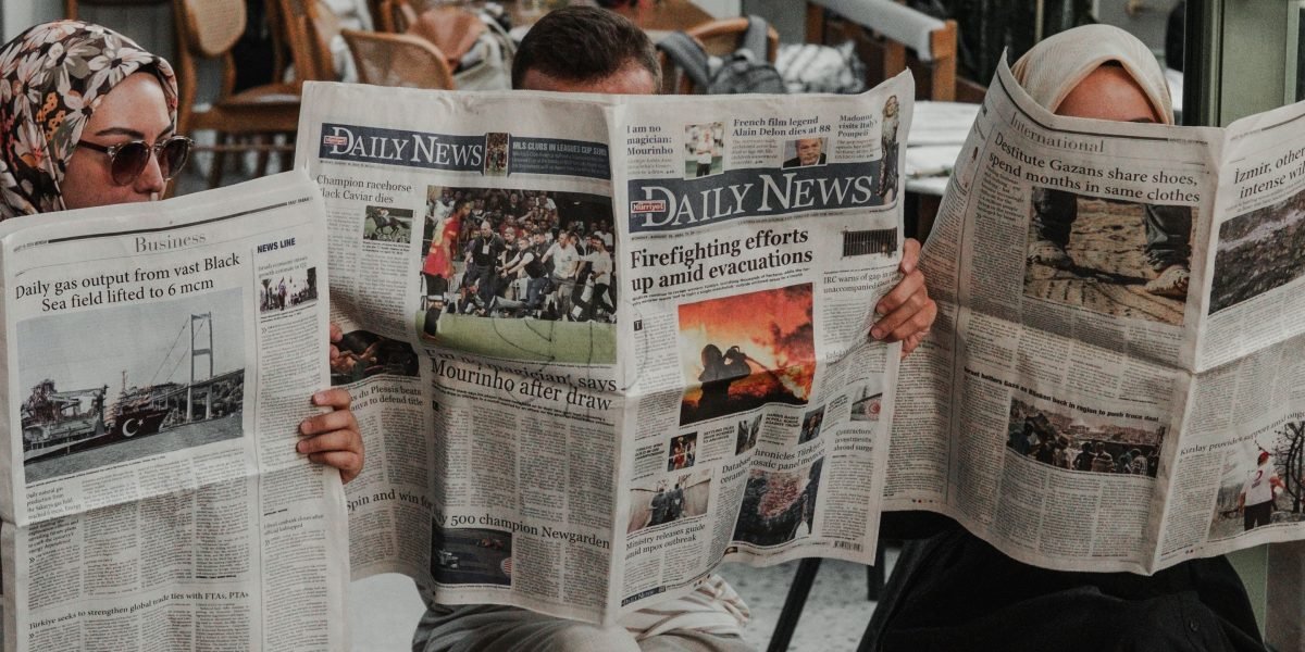 A person absorbed in reading local news, connecting with their community's stories.