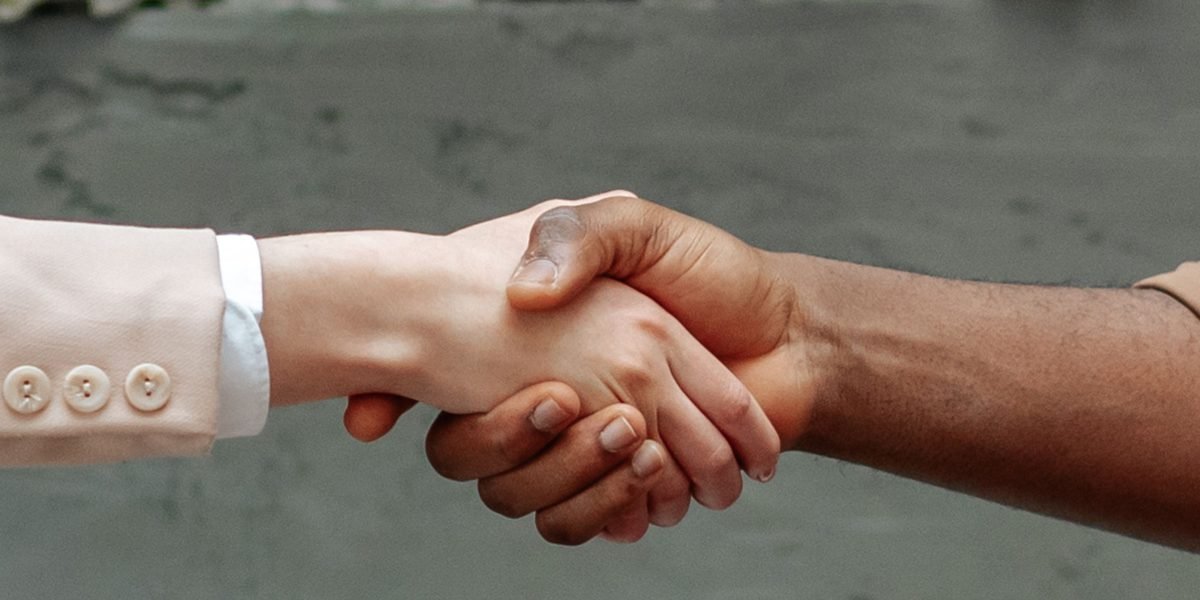 Two business professionals shaking hands firmly, symbolizing a trusted and successful partnership.