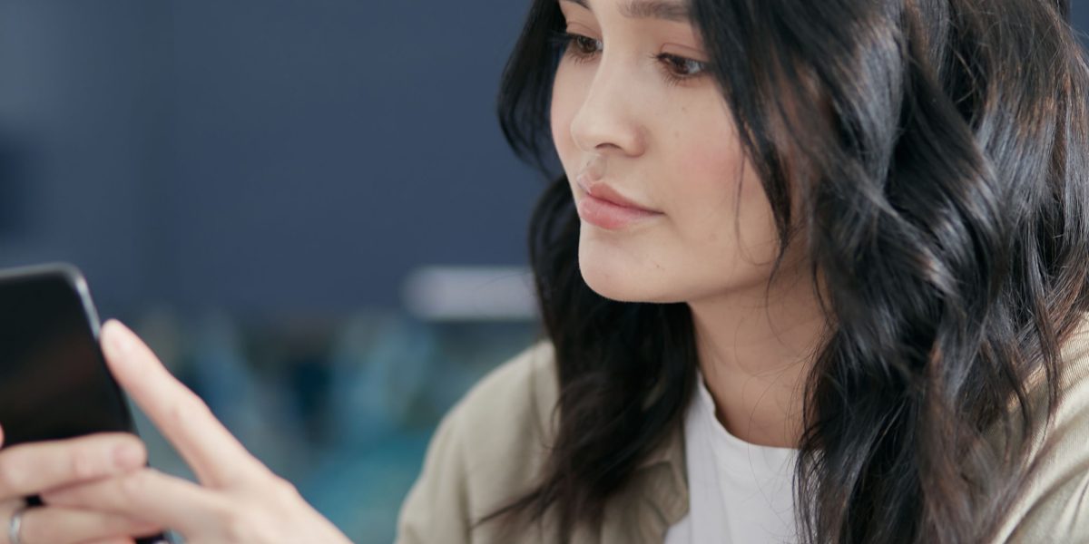 A person engages thoughtfully with online news, reflecting on the challenge of information overload and misinformation.